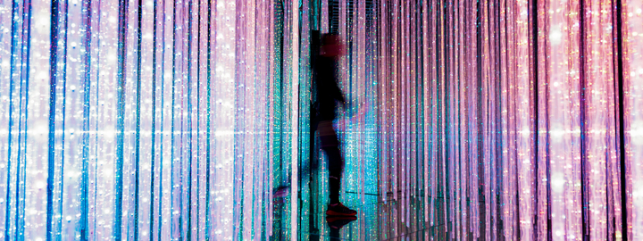 Person walking through strands of lights